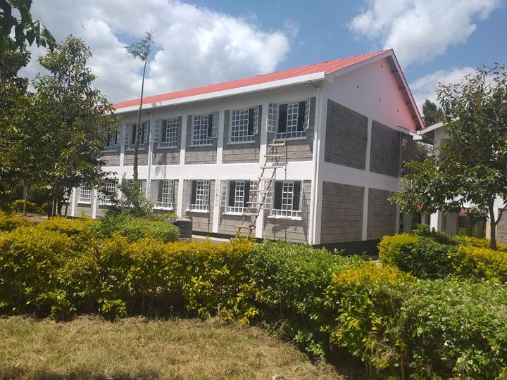 Classroom block behind a trimmed hedge
