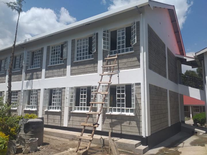 Classroom block with window frames fitted and a ladder against the wall