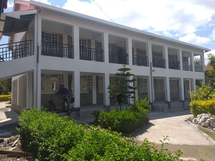 Two-storey classroom block with an upper veranda and red roof