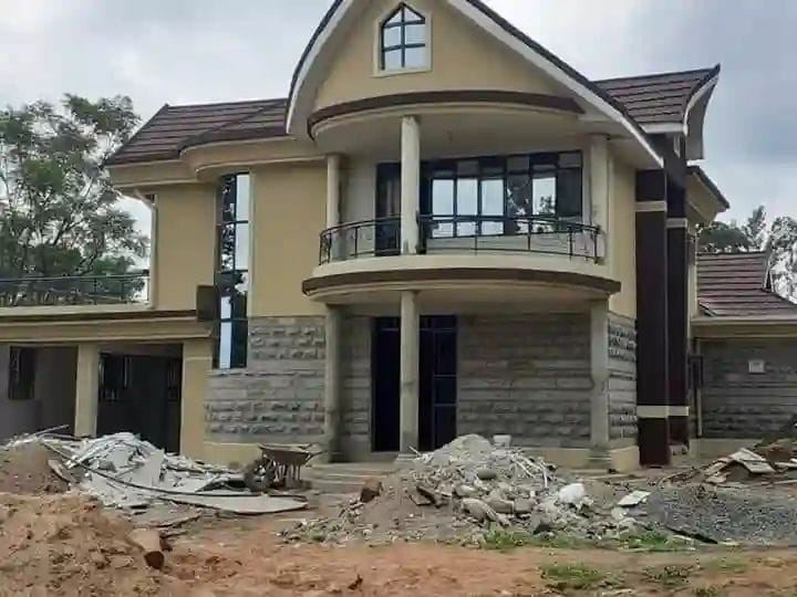 Two-storey residence with a curved balcony bay and stone base